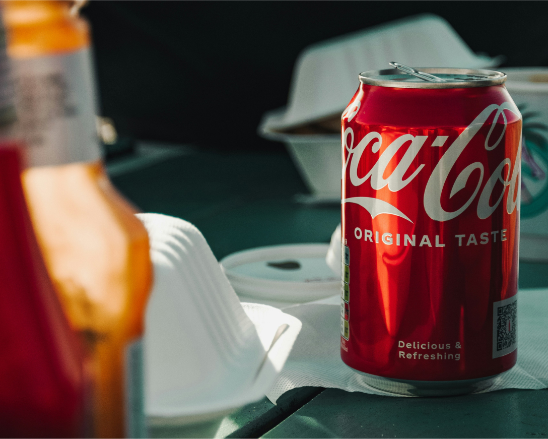 a can of coke dramatically lit surrounded by takeout containers
