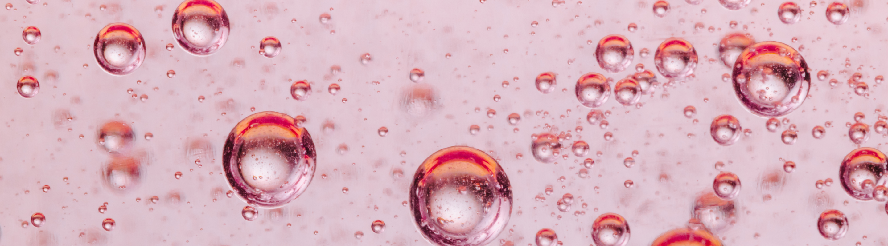 photograph of bubbles in rose colored liquid